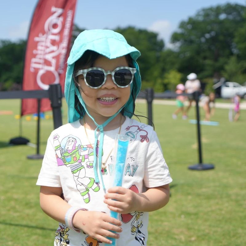 Girl smiles at Clayton park, holding popsicle