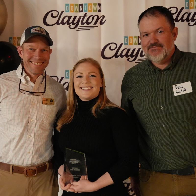 Jordan Robinson of the Magnolia Inn holds award with Councilmember Porter Casey and Paul Auclair